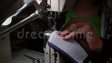 缝纫机上妇女手工缝制的特写。 工人为制鞋缝制皮革. 4K